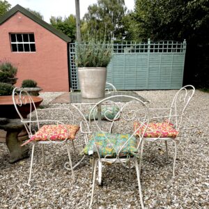 Italian mid-century garden table with a glass top and 4 metal chairs.