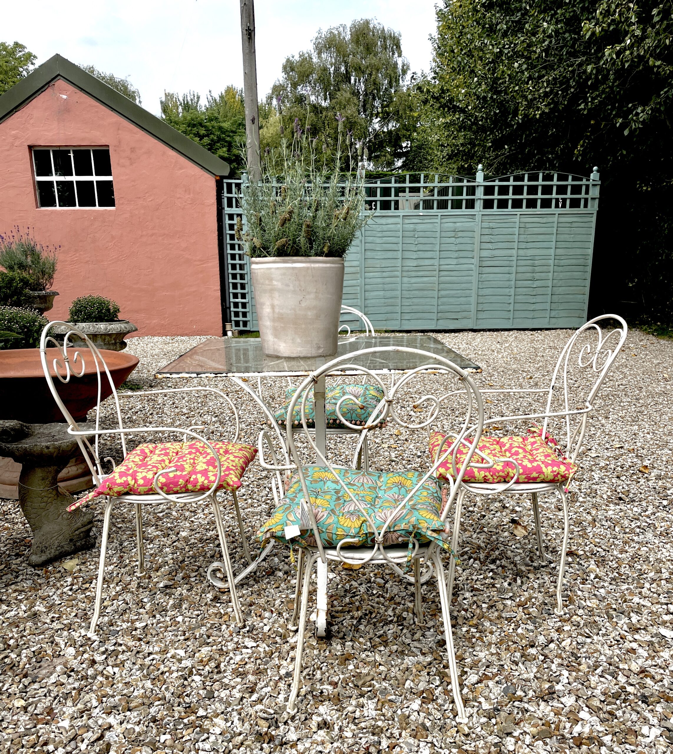 Italian mid-century garden table with a glass top and 4 metal chairs.