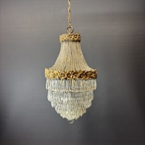 Glamorous chandelier dripping with crystals and crowned with gilded flowers.